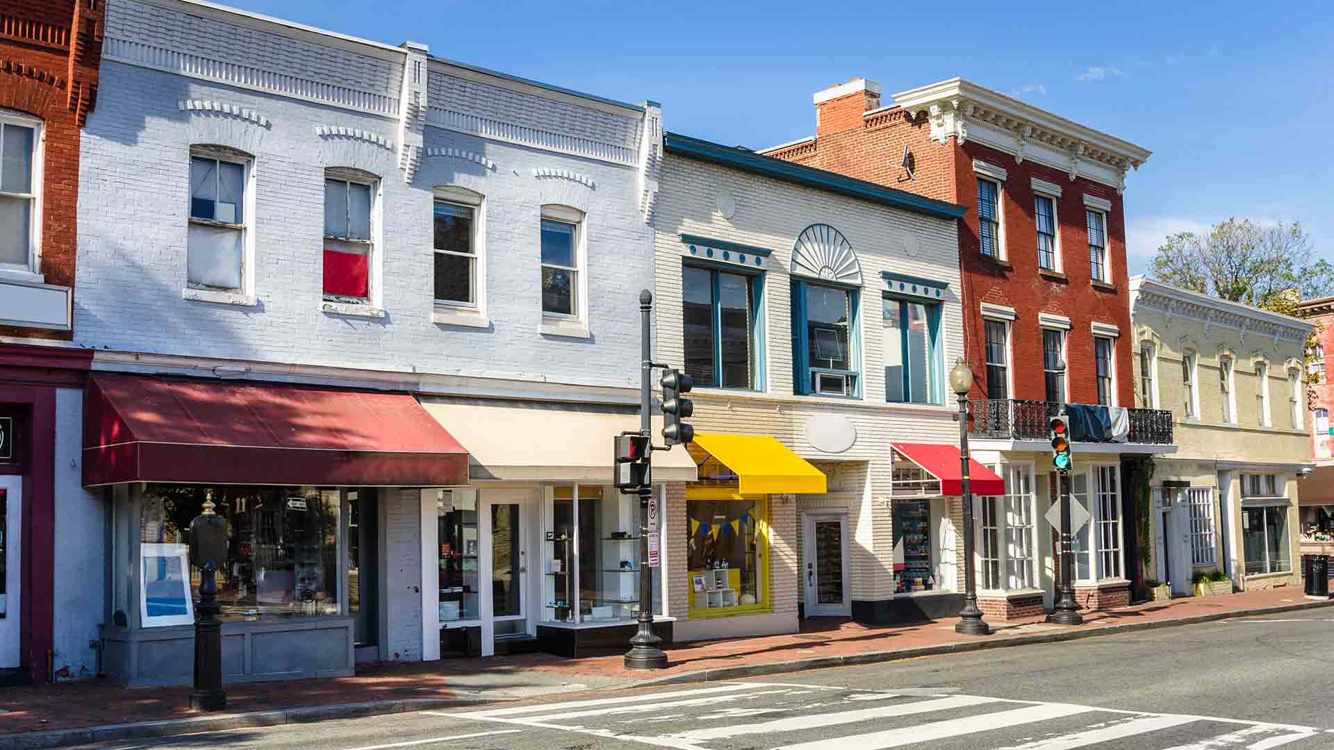 Shops along a brick sidewalk on a clear autumn day